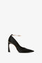 Pointy Toe Pump in Black Satin by Victoria Beckham, with a pointed toe and an ankle strap featuring a metallic detail, against a white background, and elevated by a sleek 100mm heel.