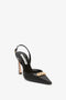 A Pointy Toe Sling back in Black Calf by Victoria Beckham with an ankle strap and a gold chain detail on the pointed toe.