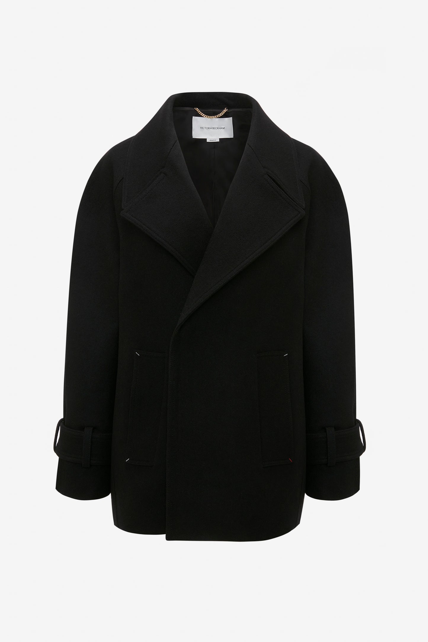 Oversized Pea Coat In Black by Victoria Beckham with wide lapels and flap pockets, showcasing masculine tailoring and adjustable strap details on the sleeves.