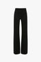 Back view of black high-waisted, wide-leg Alina Tailored Trouser In Black with two rear pockets and belt loops, exuding a 70s style reminiscent of Victoria Beckham's iconic designs by Victoria Beckham.