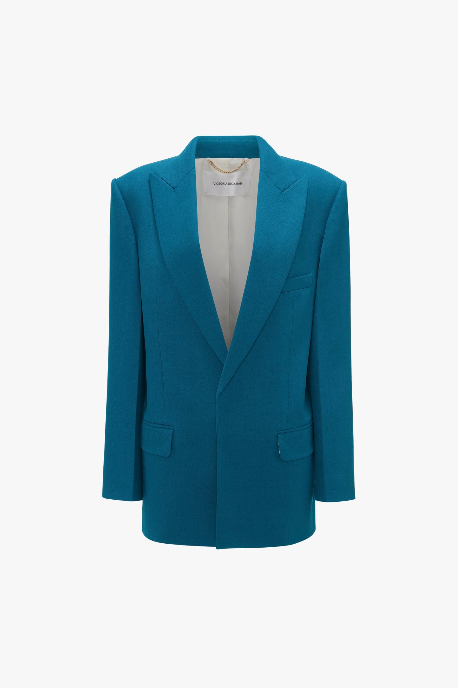 Teal. Single-button men's suit jacket with a peak lapel, two front pockets, and a hanging chain for display, featuring an oversized silhouette that adds modern flair.
Product Name: Peak Lapel Jacket In Petroleum
Brand Name: Victoria Beckham