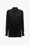 A black, tuxedo-inspired button-down long-sleeve shirt with a collar and buttoned cuffs exudes modern femininity in the form of the Contrast Bib Shirt In Black by Victoria Beckham.