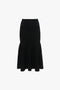 Victoria Beckham's Fit And Flare Midi Skirt In Black is a black, mid-weight stretch knit high-waisted skirt with a fitted upper portion, contrasting stitching, and a flared hem.