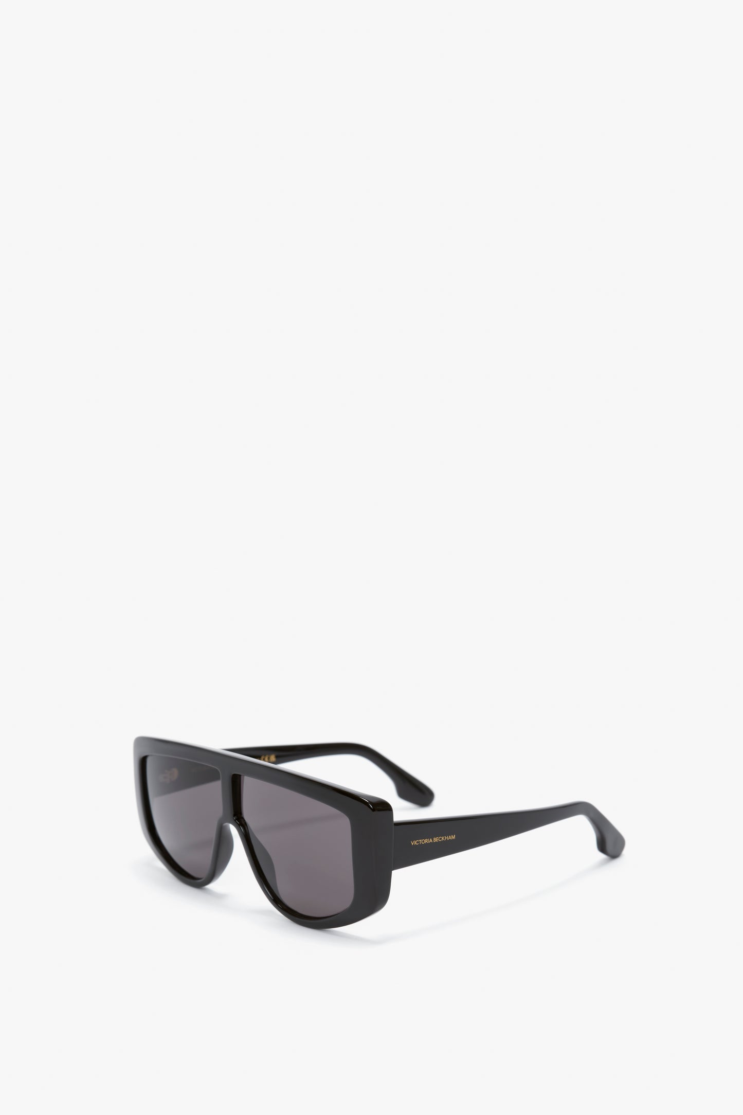 Black rectangular sunglasses with dark lenses and a slightly thick frame, resting on a white background. These could easily be mistaken for the Acetate Visor Sunglasses In Black from Victoria Beckham.