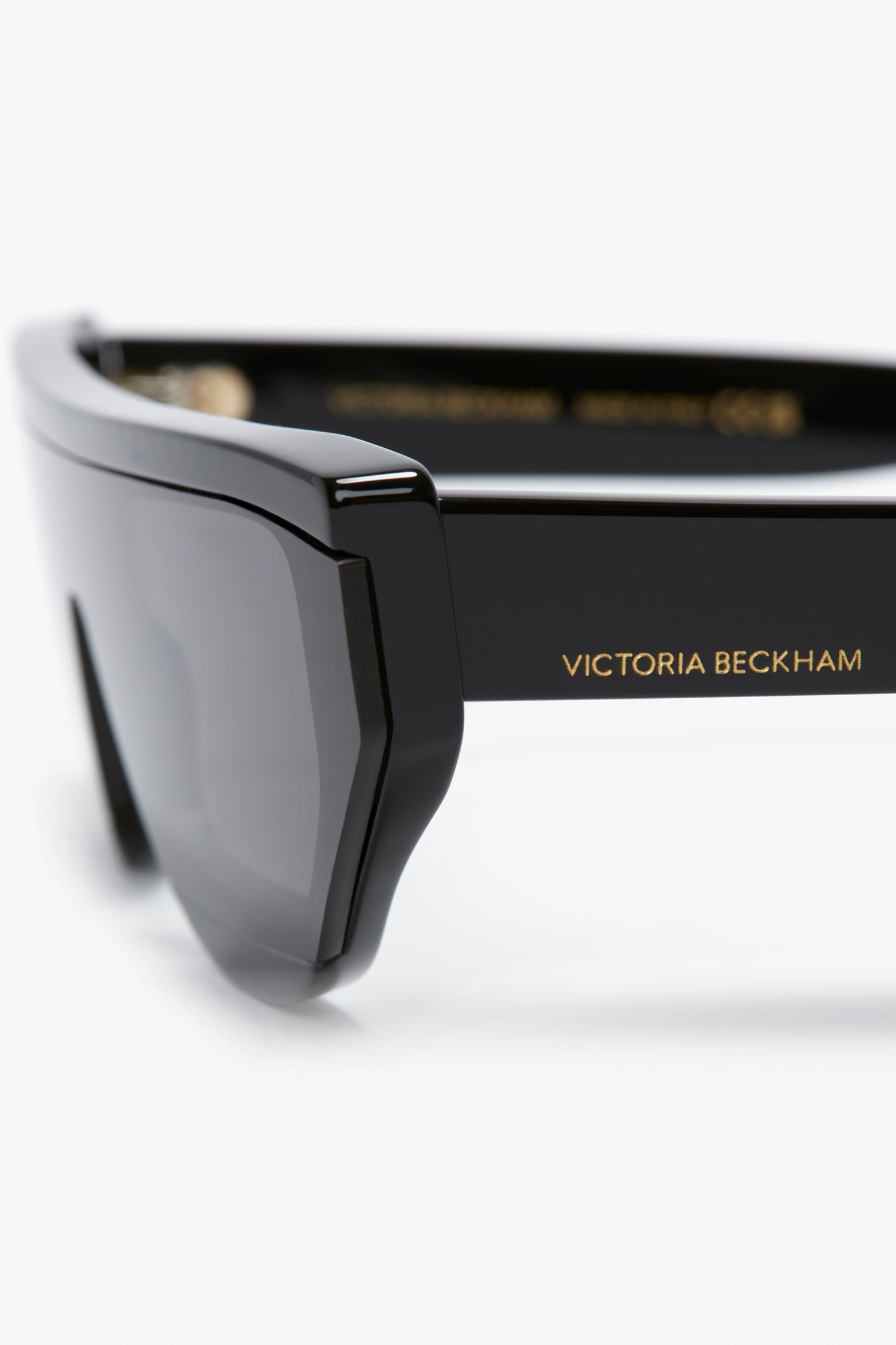 Close-up of black sunglasses featuring the "Layered Lens Visor Sunglasses In Black" by Victoria Beckham, showcasing the elegant design of Victoria Beckham eyewear from the SS24 collection.