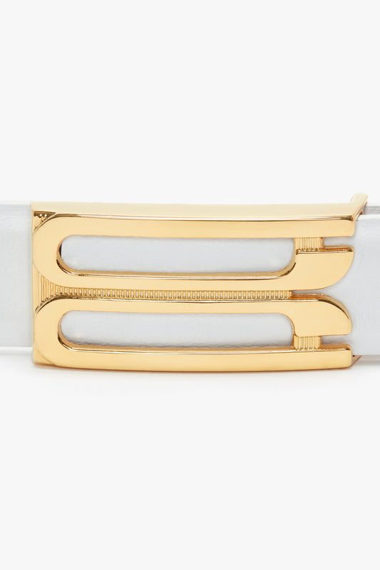 A close-up of a Victoria Beckham Frame Belt In White Leather in smooth calf leather with a rectangular gold buckle featuring dual horizontal cut-out designs.