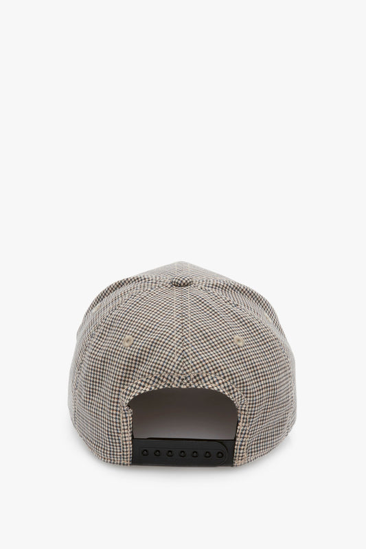 A beige and brown checkered baseball cap made from wool dogtooth check, viewed from the back, showcasing its minimalist design with an adjustable snapback closure. This is the Logo Cap In Dogtooth Check by Victoria Beckham.