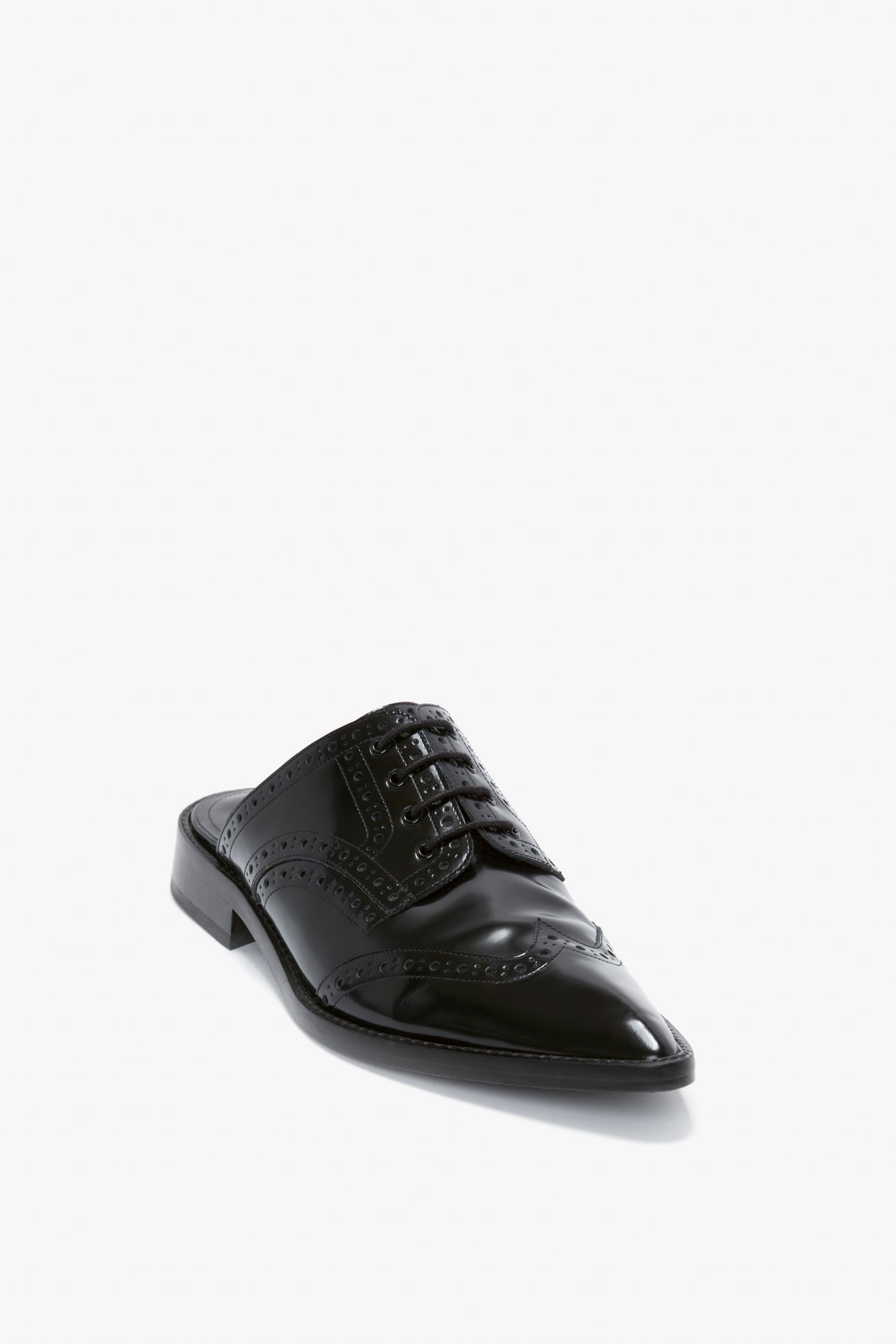 A single Victoria Beckham Flat Lace Up Mule in black leather featuring decorative perforations and a pointy toe silhouette, crafted from luxurious calfskin.