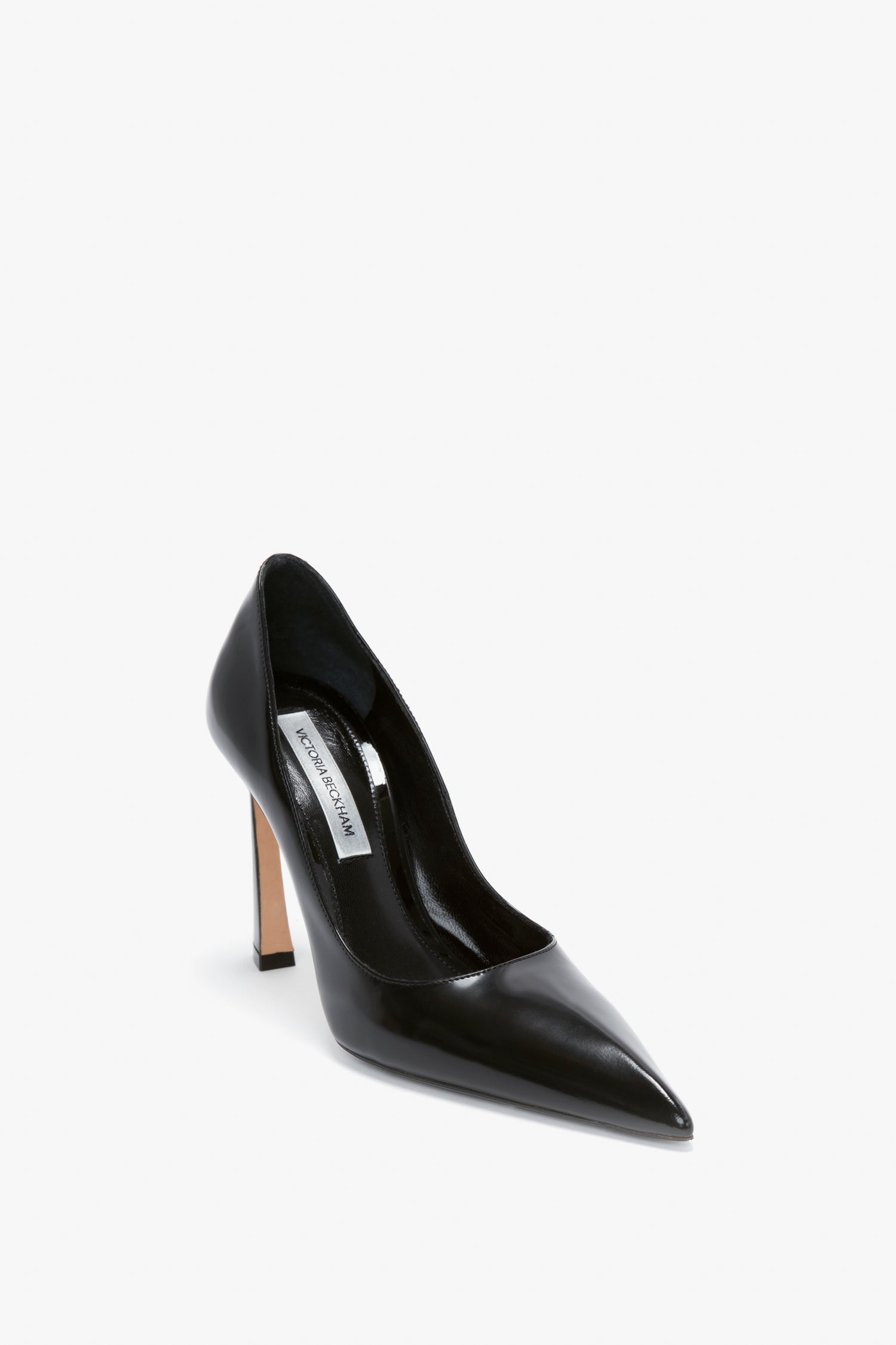 A single black V Pump In Black Brushed Leather with a pointed toe and slim sculptural heel from Victoria Beckham, elegantly displayed on a white background.