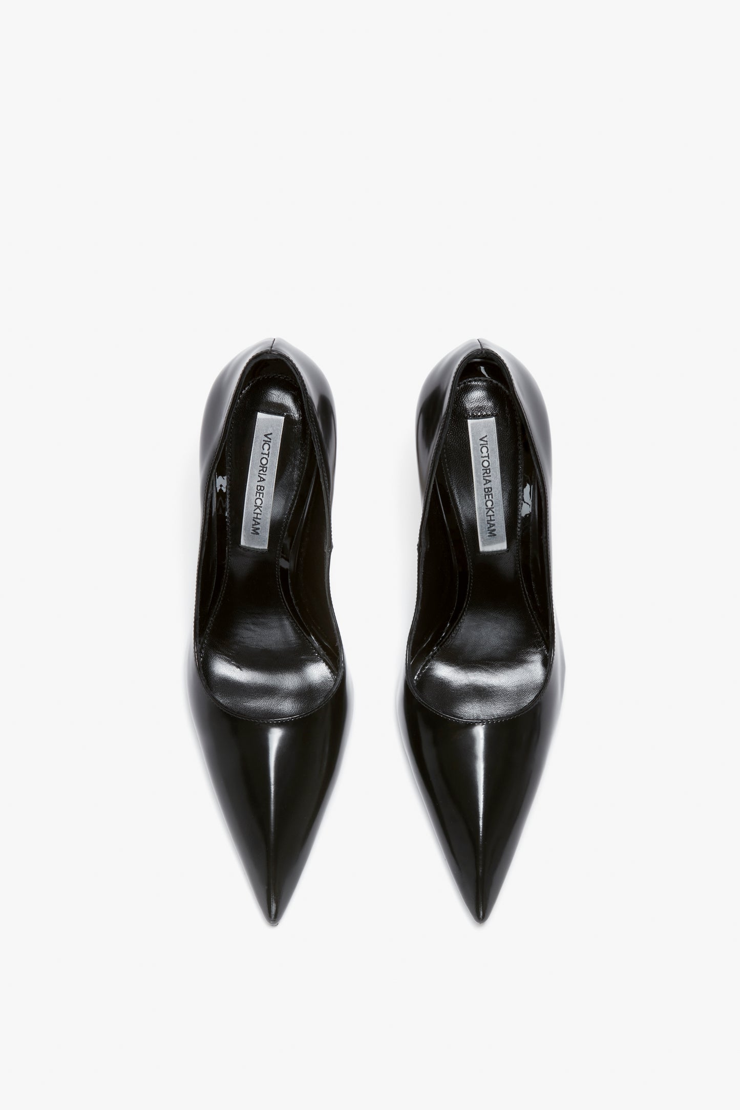 Black V Pump In Black Brushed Leather by Victoria Beckham with a sleek, glossy finish and a distinctive sculptural heel, viewed from above.