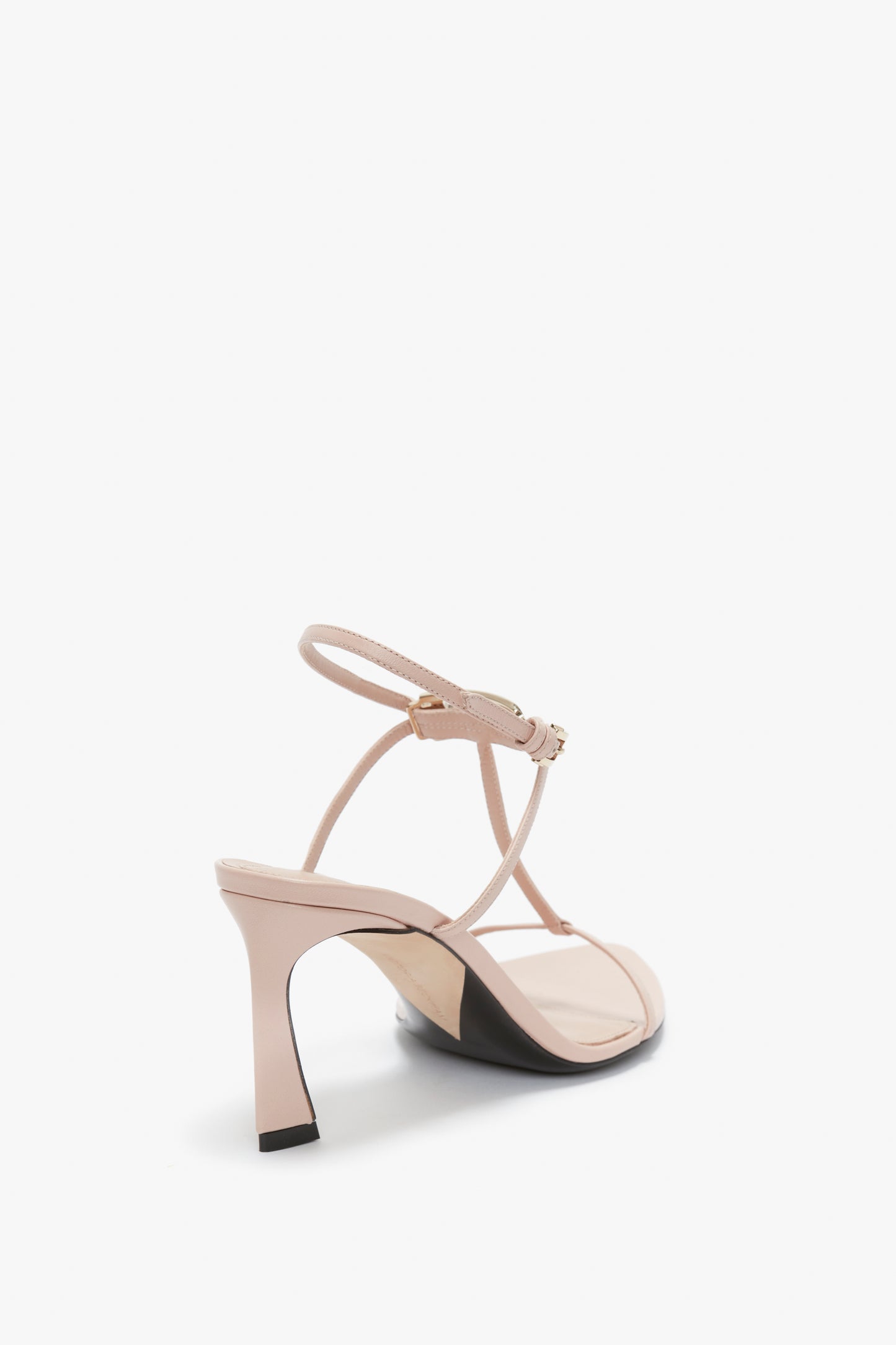 Rear view of a single Victoria Beckham Frame Detail Sandal In Nude Leather with an adjustable ankle strap, V-shaped sculptural heel, and open toe design on a white background.