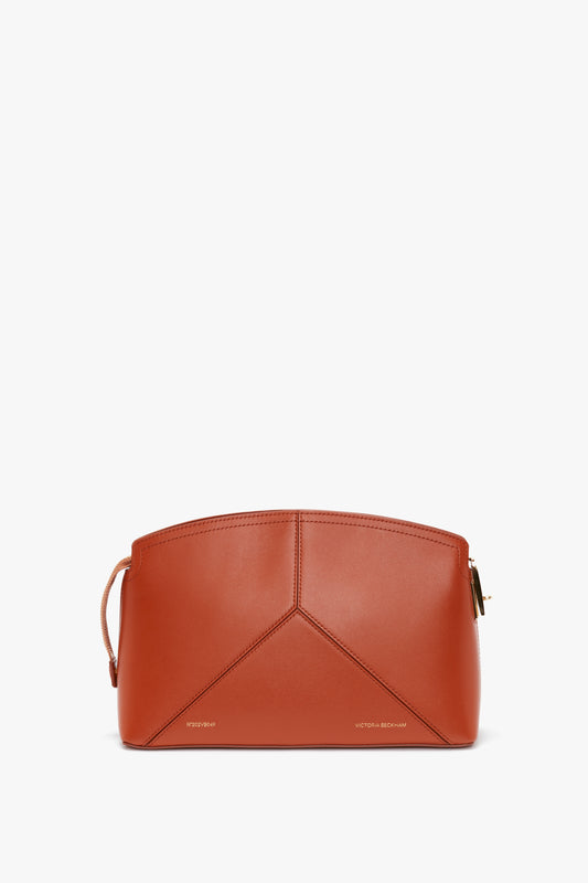 A structured Victoria Beckham Victoria Clutch Bag In Tan Leather with a top zip closure, geometric panel design, and a small strap on one side.