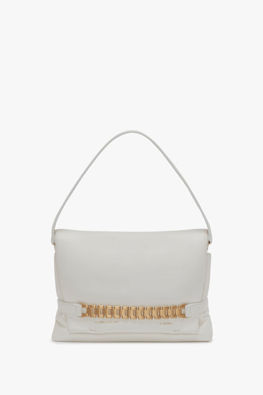 A white Victoria Beckham Puffy Chain Pouch Bag With Strap In White Leather featuring a single strap and a gold chain detail on the front.