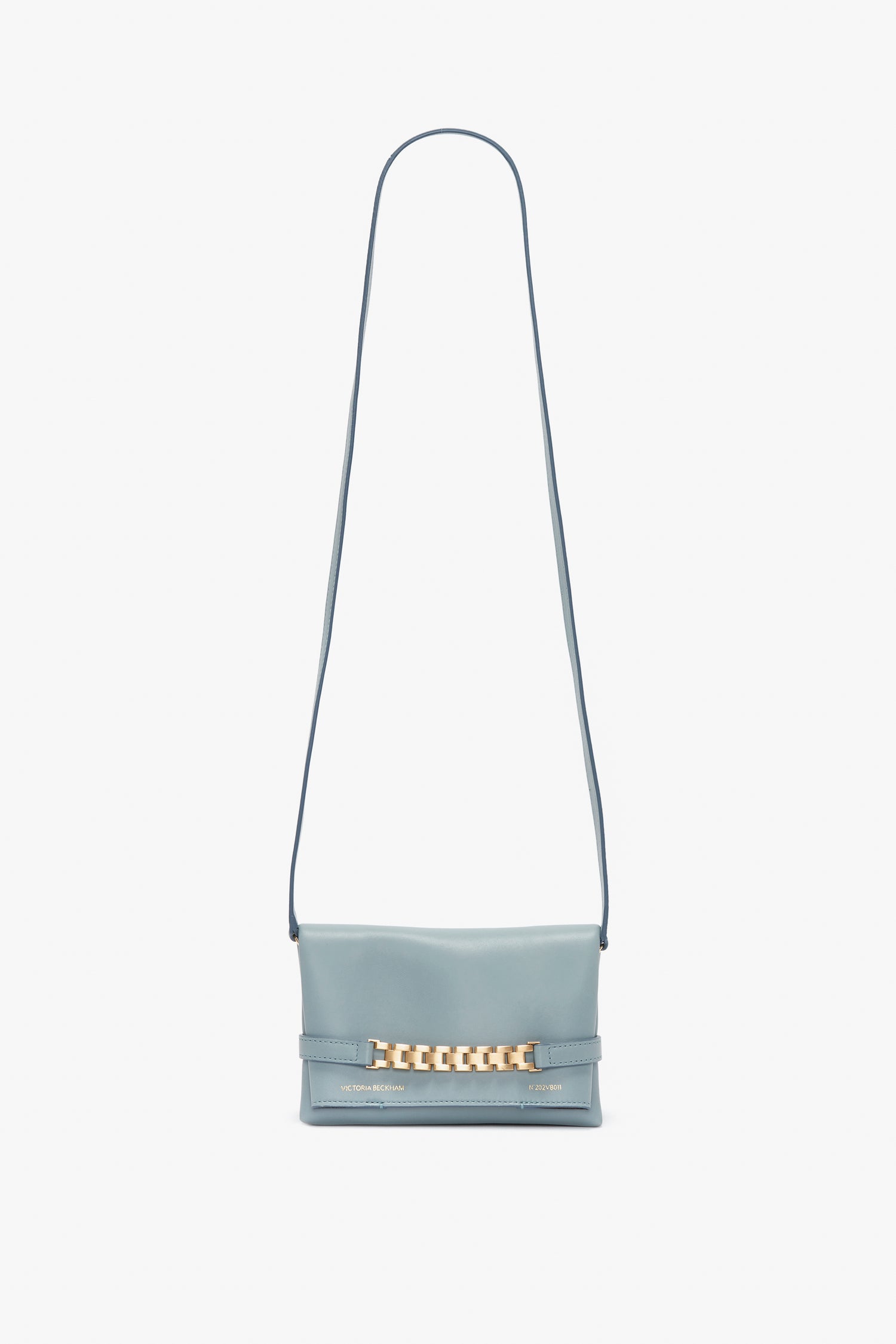 A light blue crossbody bag with a long strap and gold-tone chain detail on the front, perfect as a **Mini Chain Pouch Bag With Long Strap In Ice Leather** or an elegant clutch by **Victoria Beckham**.