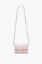 A Mini Chain Pouch Bag With Long Strap In Orchid Leather by Victoria Beckham, set against a white background.