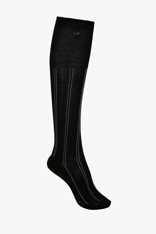 A single Victoria Beckham Superfine Rib Socks In Black knee-high sock with vertical light blue stripes and a ribbed top edge, made from 100% cotton, isolated on a white background.