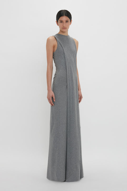 Person wearing a sleeveless, floor-length Frame Detailed Maxi Dress In Titanium by Victoria Beckham standing against a plain white background.