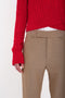 A person is wearing a red cable-knit sweater paired with Victoria Beckham's Wide Cropped Flare Trouser In Tobacco. The image is cropped to focus on the torso and upper legs, showcasing the flattering hint of ankle.