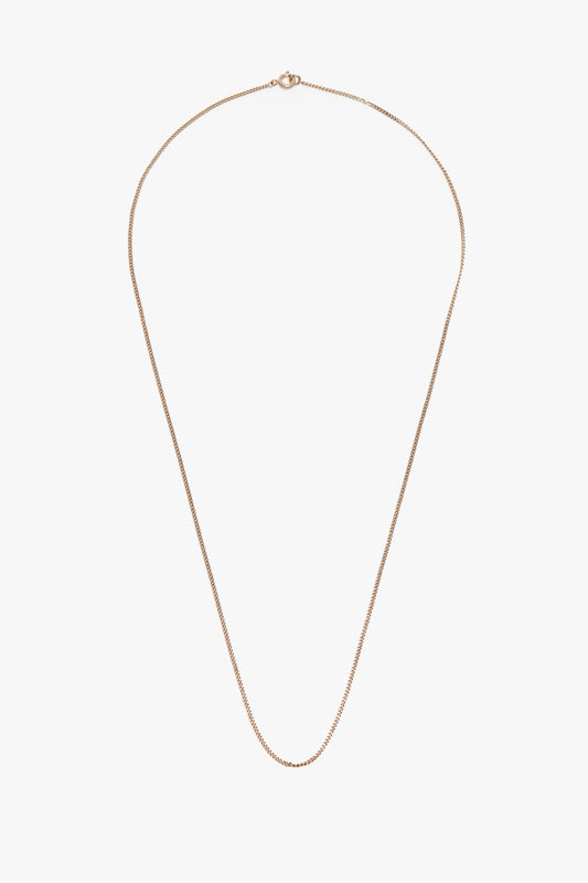 A simple gold-plated brass Victoria Beckham Exclusive Long Fine Chain In Gold with a fine link design and a small, circular clasp at the top against a white background.