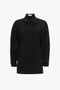 A long-sleeved black **Waistcoat Detail Ponti Top In Black** by **Victoria Beckham**, featuring a stand-up collar, front placket detail, and an oversized fit for a contemporary twist.