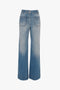 A pair of blue wide-leg jeans with front patch pockets and a high waist, crafted in vintage denim style, displayed against a white background: Alina High Waisted Jean In Light Summer Wash by Victoria Beckham.