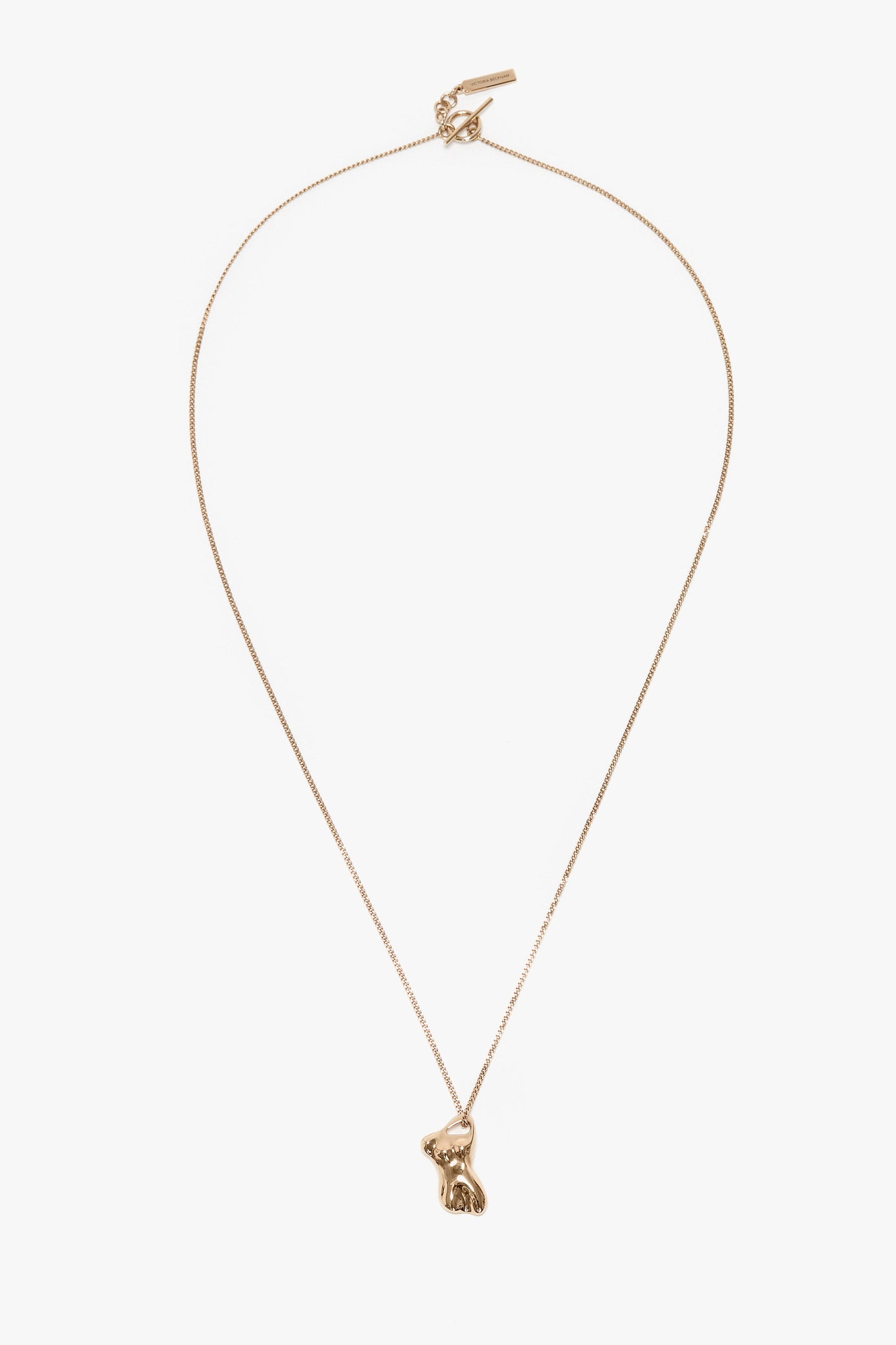 A light gold necklace featuring a delicate chain and a 100% brass pendant shaped like a sitting rabbit, this Exclusive Body Charm Necklace In Light Gold by Victoria Beckham is an exquisite accessory.