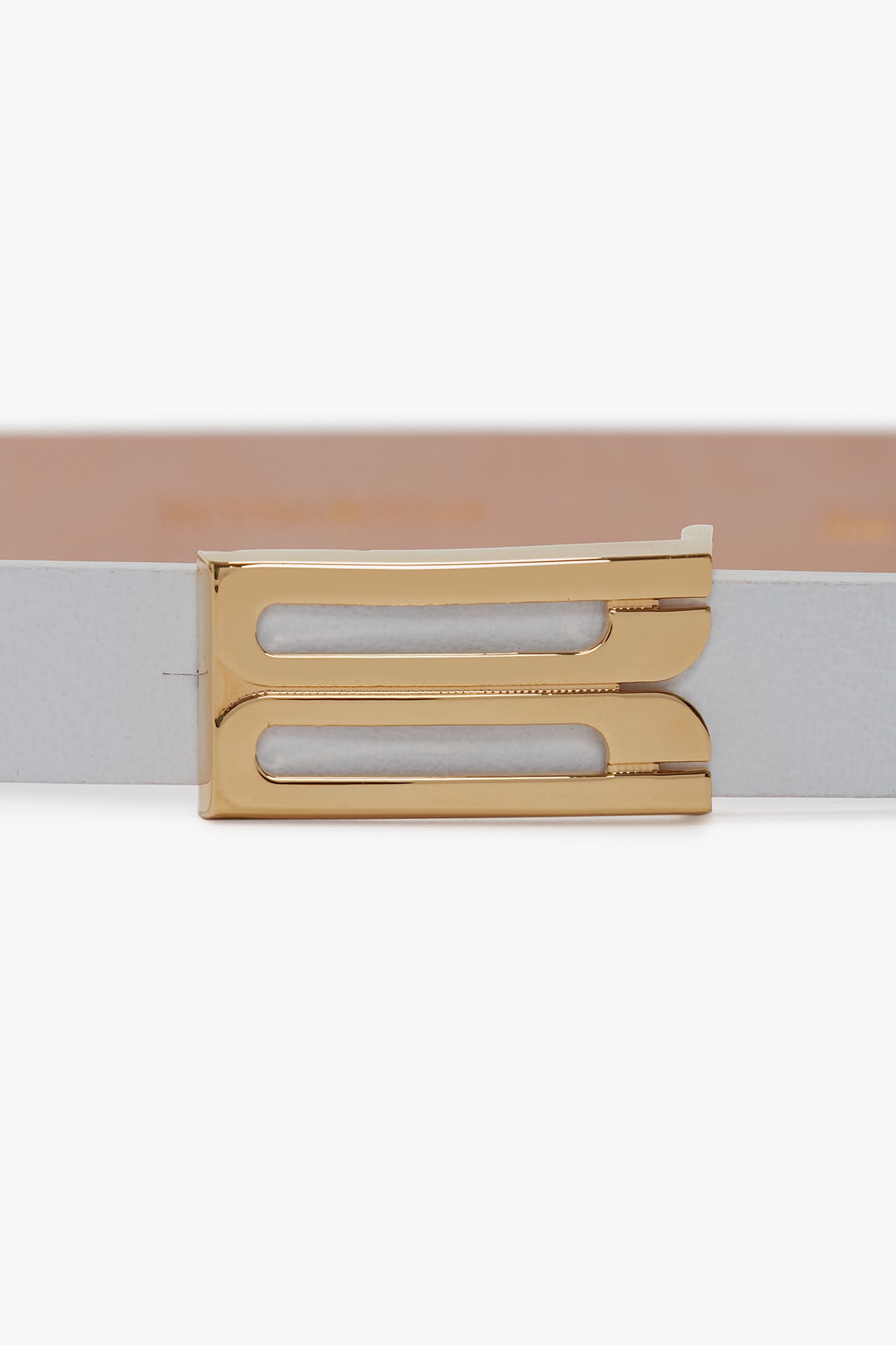 A close-up of a beige Victoria Beckham Exclusive Micro Frame Belt In White Leather with a gold rectangular buckle.