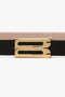 Close-up of a Victoria Beckham Exclusive Micro Frame Belt In Black Leather with a gold rectangular buckle, isolated on a white background.