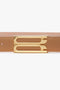 Close-up image of the Victoria Beckham Frame Belt In Camel Leather, showcasing luxury gold hardware with a double-bar design.