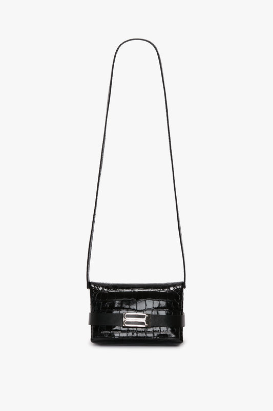 Mini B Pouch Bag In Croc Effect Black Leather by Victoria Beckham in calf leather with a long, detachable crossbody strap and a silver clasp on the front, featuring a textured, crocodile-like pattern.