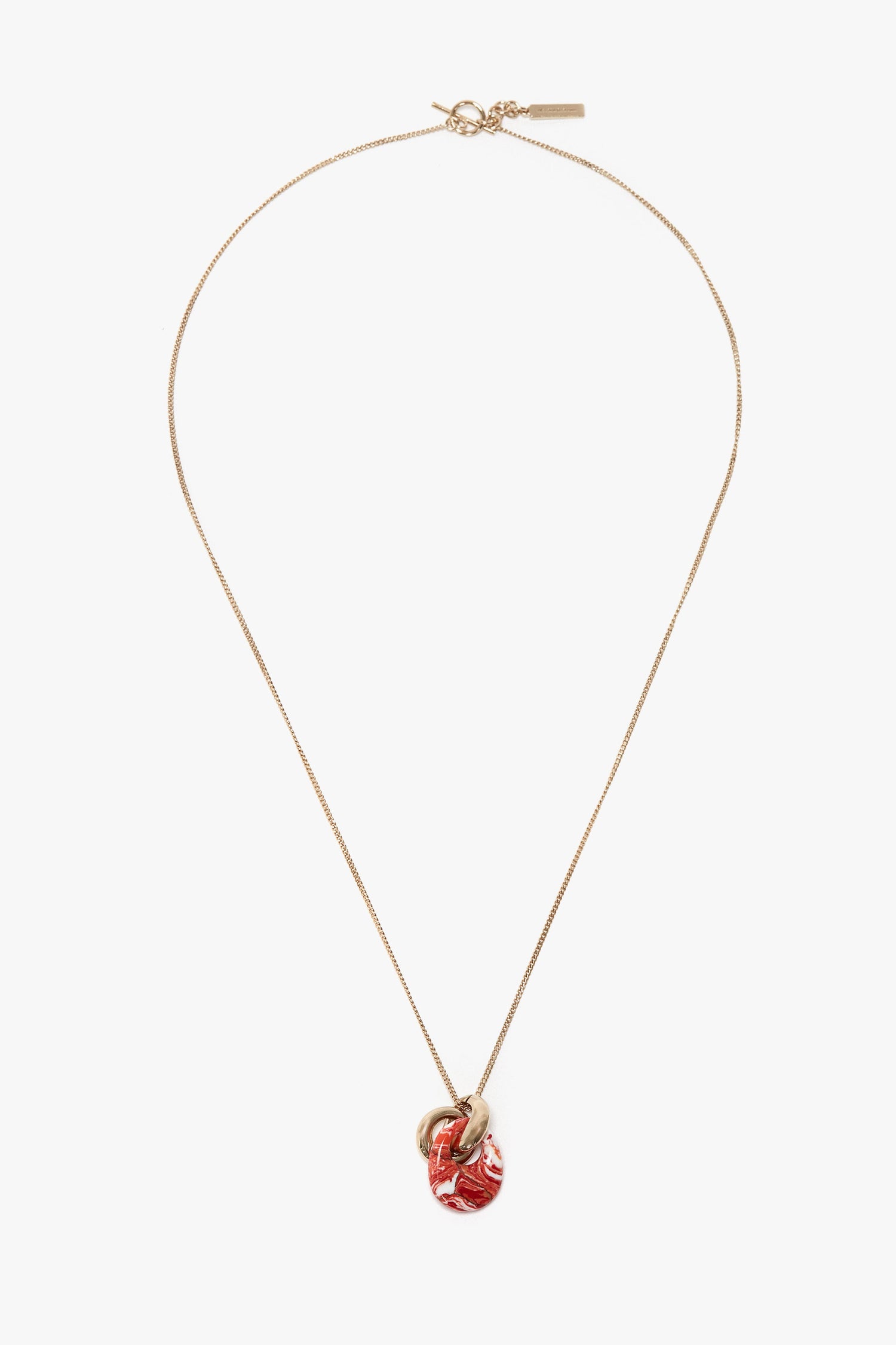 The Victoria Beckham Exclusive Resin Pendant Necklace In Light Gold-Orange is crafted from 100% brass, featuring a small red and gold resin pendant.