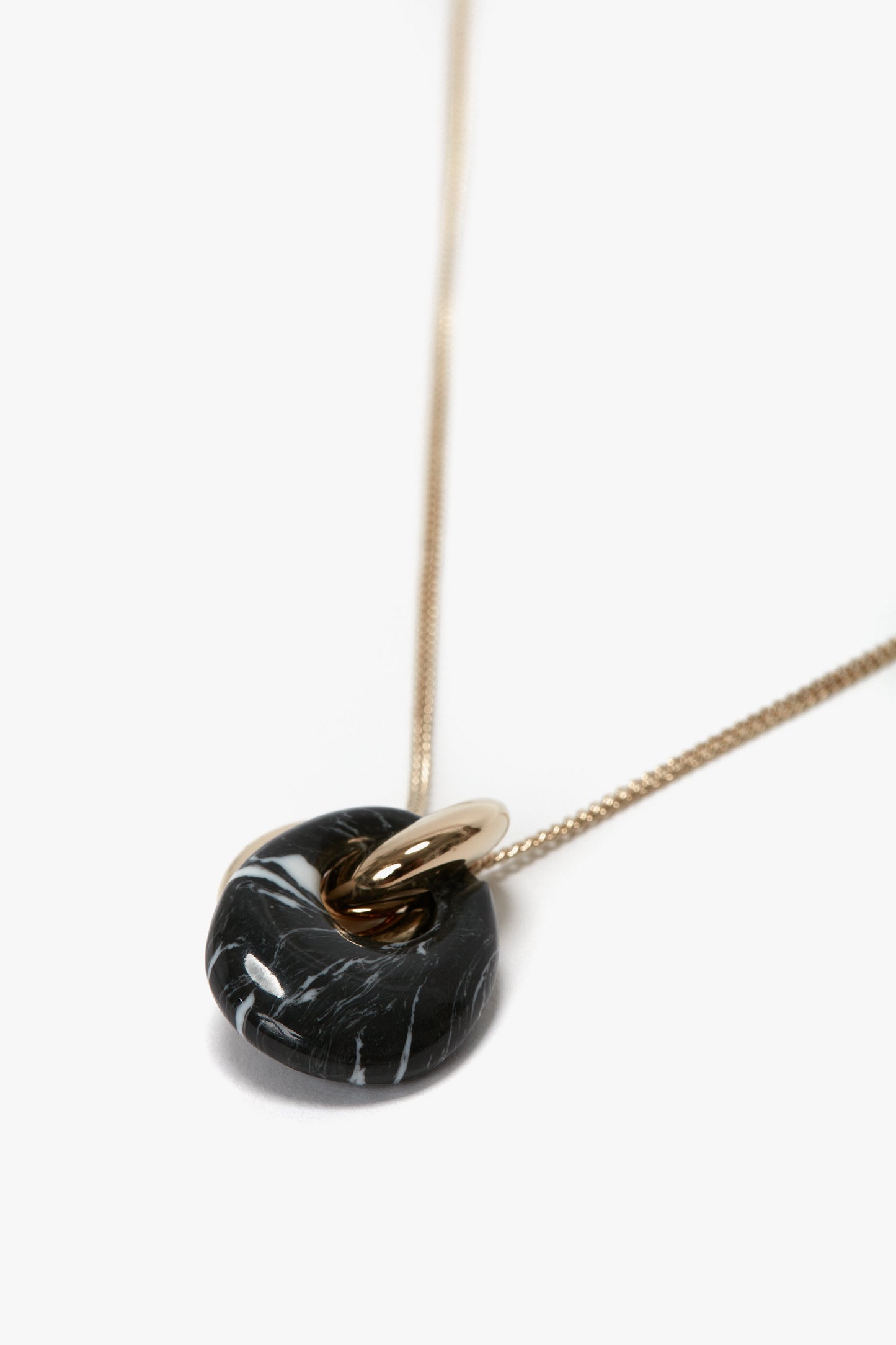 A gold chain necklace with a black and white marbled resin pendant adds a touch of elegance, while its T-bar closure ensures ease of wear. This is the Exclusive Resin Pendant Necklace In Light Gold-Black by Victoria Beckham.