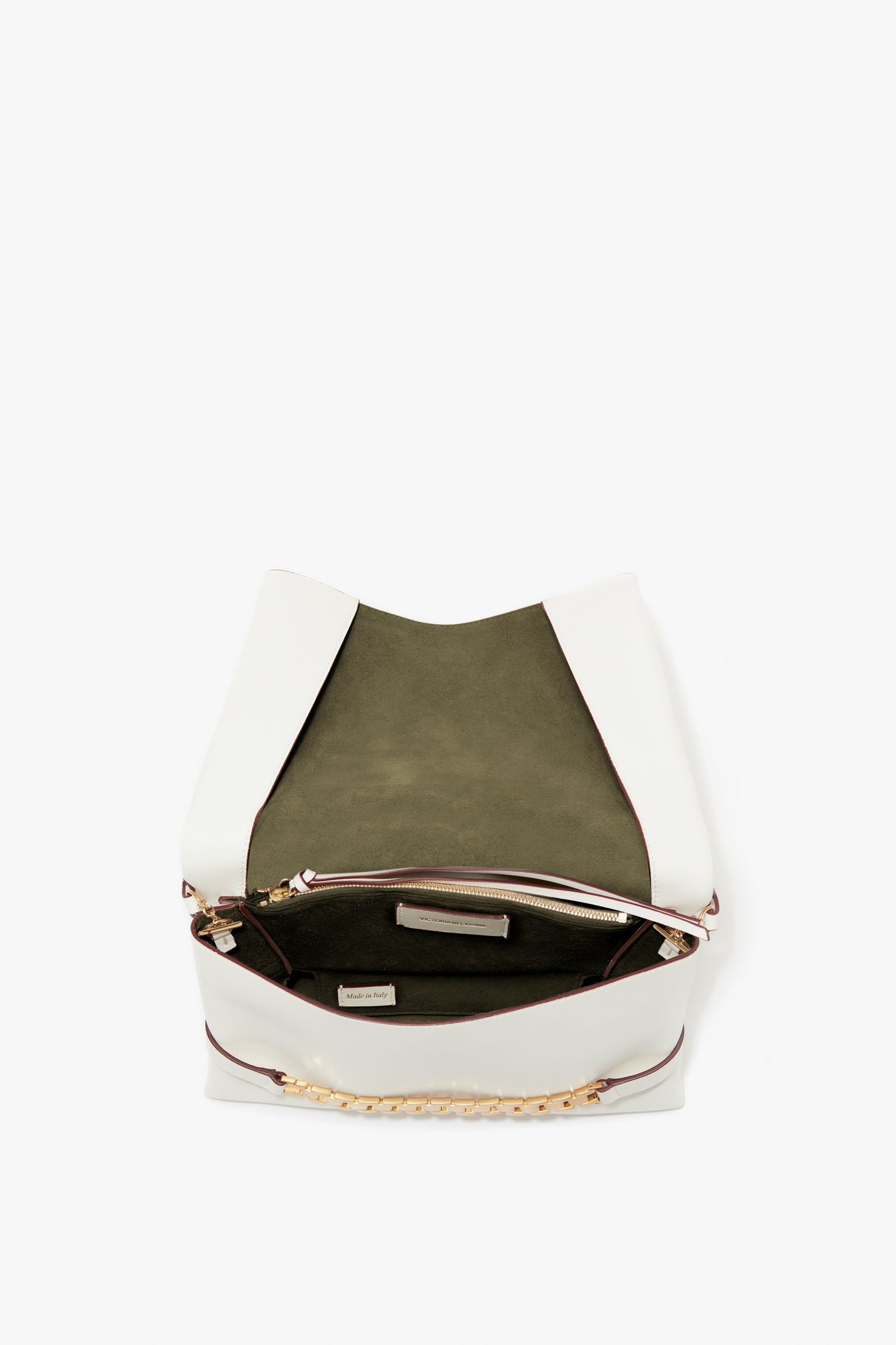 Top view of an open Chain Pouch Bag with Strap In White Leather by Victoria Beckham, revealing a green interior lining and a zippered pocket.