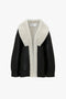 Shearling Coat In Monochrome by Victoria Beckham with a wide, cream black shearling collar and lining, shown against a plain white background. The design emphasizes an oversized silhouette, making it a statement shearling coat perfect for any stylish wardrobe.