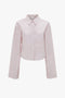 A light pink Victoria Beckham Button Detail Cropped Shirt In Rose Quartz with a chest pocket, collar, and refined button sleeve detail.