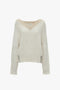 Cream V-neck jumper with a traditional cable knit design and long sleeves. Crafted from pure lambswool, the Victoria Beckham V-Neck Jumper In Natural features intricate patterns and details throughout.