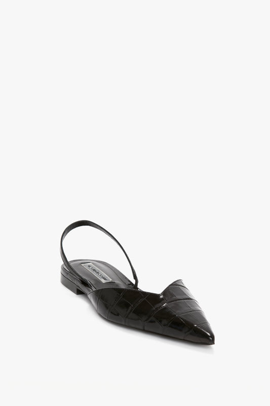 A black, pointed-toe slingback flat shoe with a textured, croc-embossed calf leather finish and a low heel, featuring an asymmetric V cut, set against a white background: the Victoria Beckham V Cut Sling Back In Black Croc-Effect Leather.