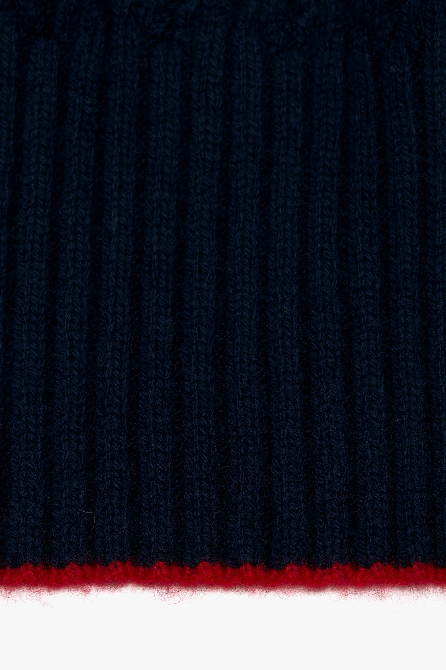 Close-up of a navy Exclusive Logo Patch scarf with a thin red stripe at the bottom and a Victoria Beckham logo patch.