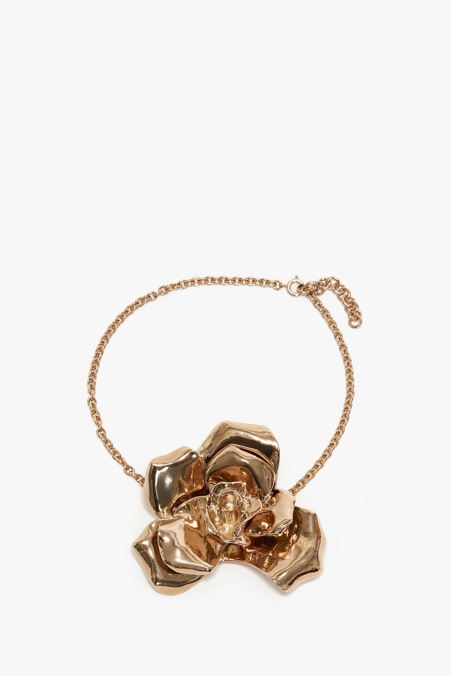 An Exclusive Flower Necklace In Gold by Victoria Beckham featuring a large, metallic rose with intricate petals as the central design, making it a perfect statement accessory.