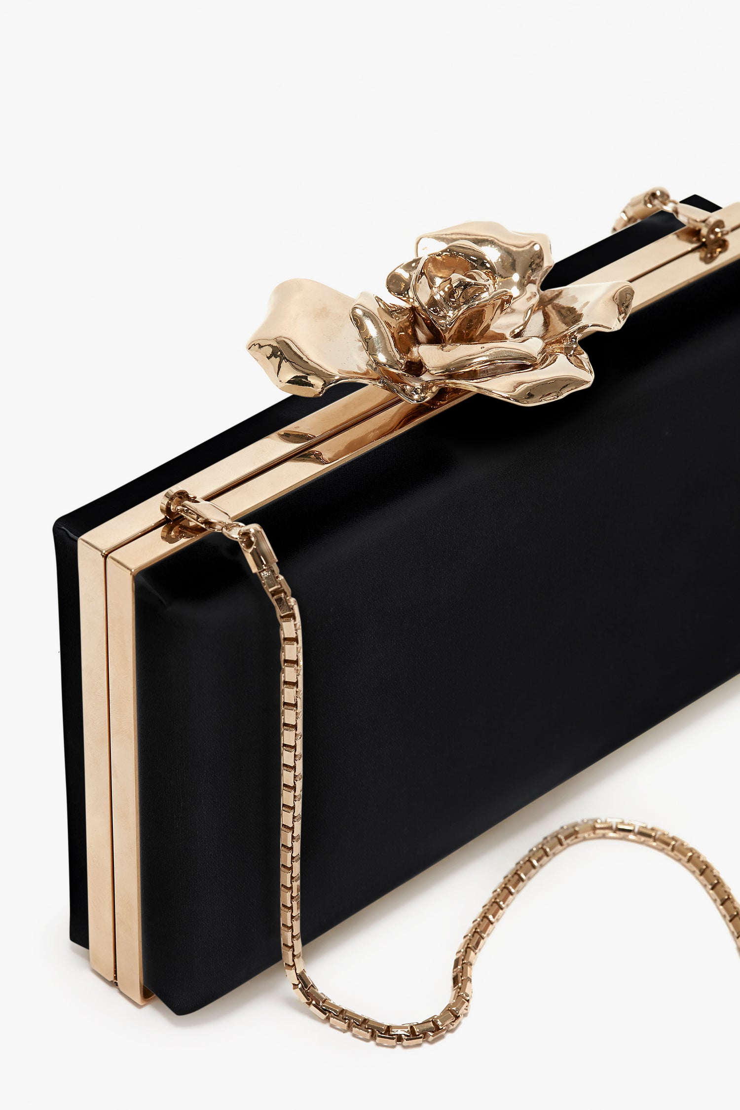 Frame Flower Minaudiere Bag in Black by Victoria Beckham with gold trim, featuring an exquisite flower clasp and a bespoke brass frame, complemented by a gold chain strap.