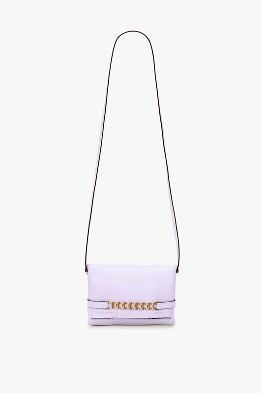 A light purple, or lilac, shoulder bag with a long, thin detachable strap and an Exclusive Mini Chain Pouch Bag With Long Strap In Lilac Leather by Victoria Beckham detail on the front.