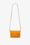 A bright mandarin structured leather shoulder bag featuring a long strap and a decorative metal chain detail on the front, perfect as the Mini Chain Pouch Bag With Long Strap In Mandarin Leather by Victoria Beckham for your essentials.