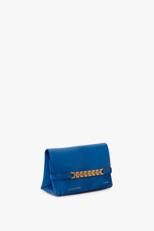 A Mini Chain Pouch Bag With Long Strap In Sapphire Blue with a gold chain detail on the front and "Victoria Beckham" embossed at the bottom.