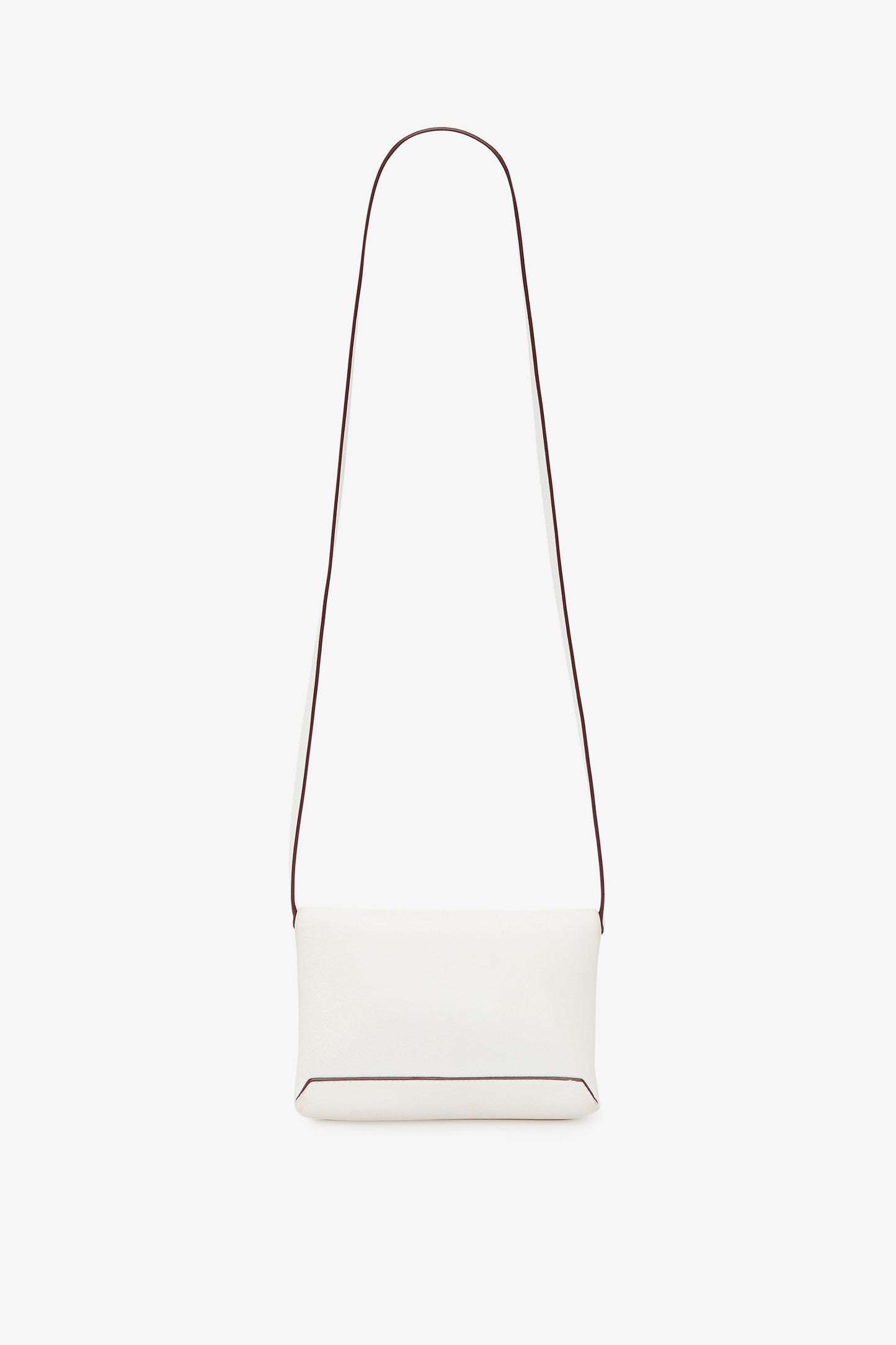 A minimalist white crossbody bag with a long, thin strap and a small rectangular body. The edges of the Victoria Beckham-inspired bag have subtle dark piping. The Mini Chain Pouch Bag With Long Strap In White Leather by Victoria Beckham comes with a removable strap for versatile styling options against the plain white background.