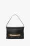 A Chain Pouch Bag with Strap In Black Leather by Victoria Beckham, featuring a gold chain detail across the front and a single, detachable handle.