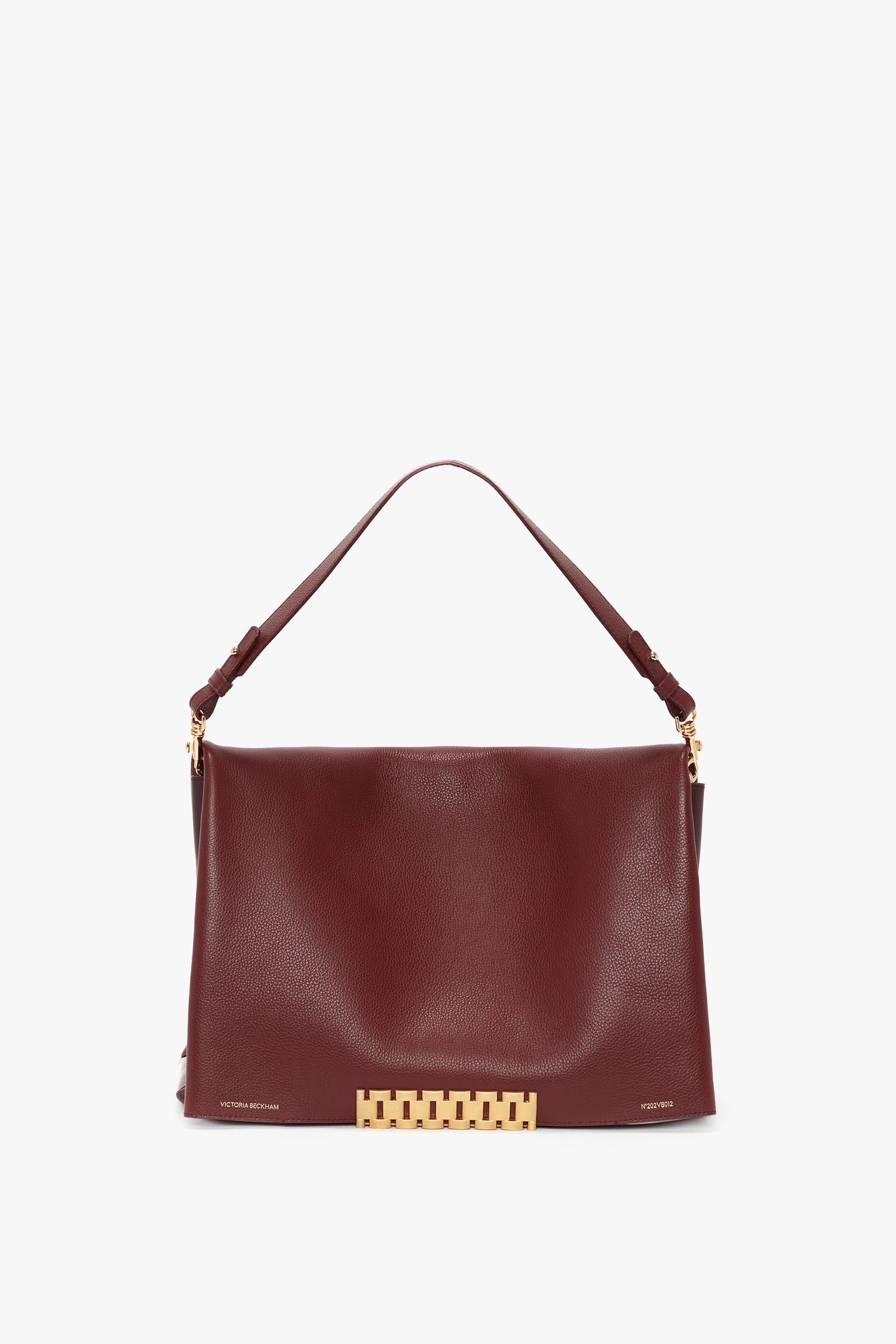 A Jumbo Chain Pouch Bag In Bordeaux by Victoria Beckham with a single shoulder strap, gold hardware, and a rectangular decorative clasp at the bottom. The bag also features a detachable strap for added versatility.